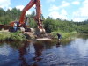 An excavator is used to place precast bridge abutments for a private bridge.
